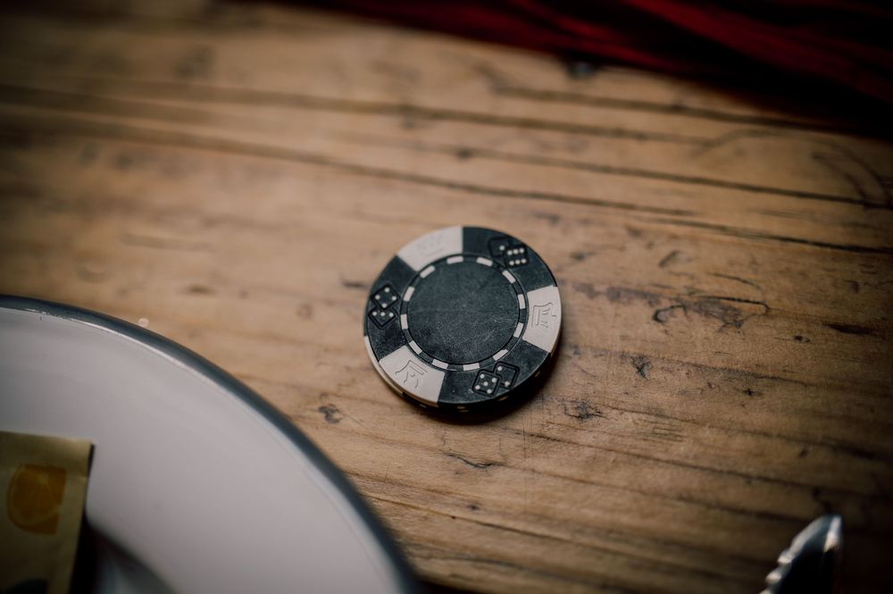 A vintage pocket watch with Roman numerals lies on a weathered wooden surface in dramatic lighting.