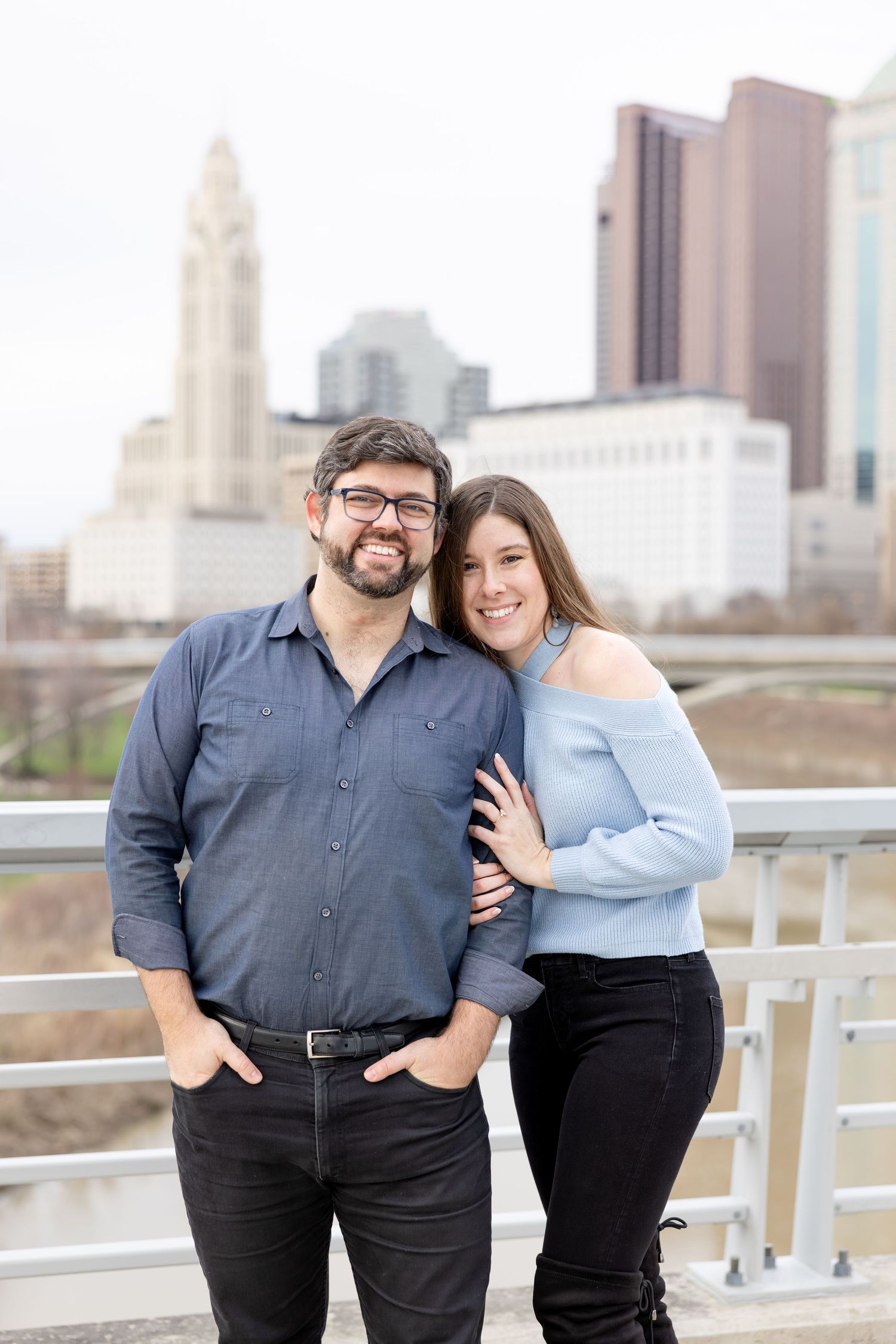 Downtown Columbus engagement photos on Main Street Bridge featuring a joyful couple with light and airy, natural movement and candid moments