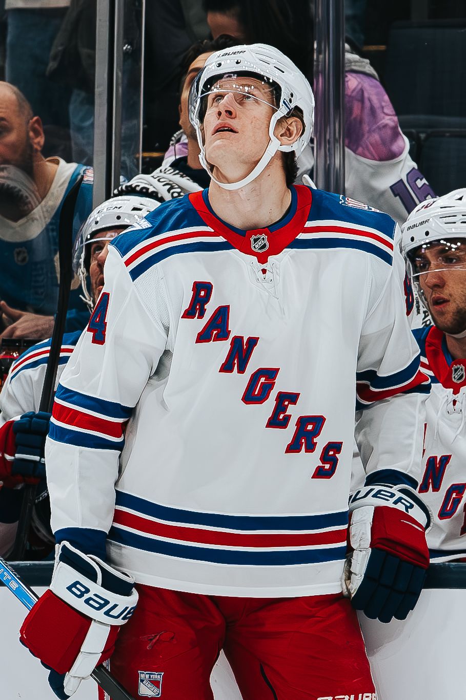 NHL hockey players in New York Rangers white and red jerseys celebrate after scoring during a game.
