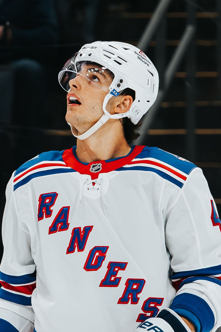 NHL hockey player in New York Rangers white home jersey looking upward during game.