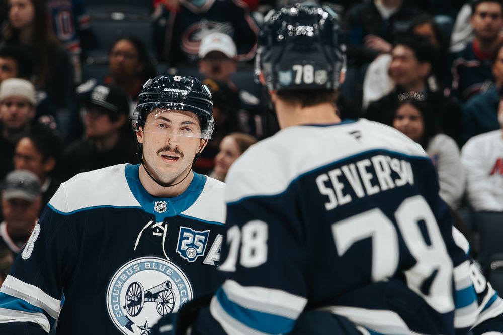 NHL players celebrate after scoring a goal during an ice hockey game.