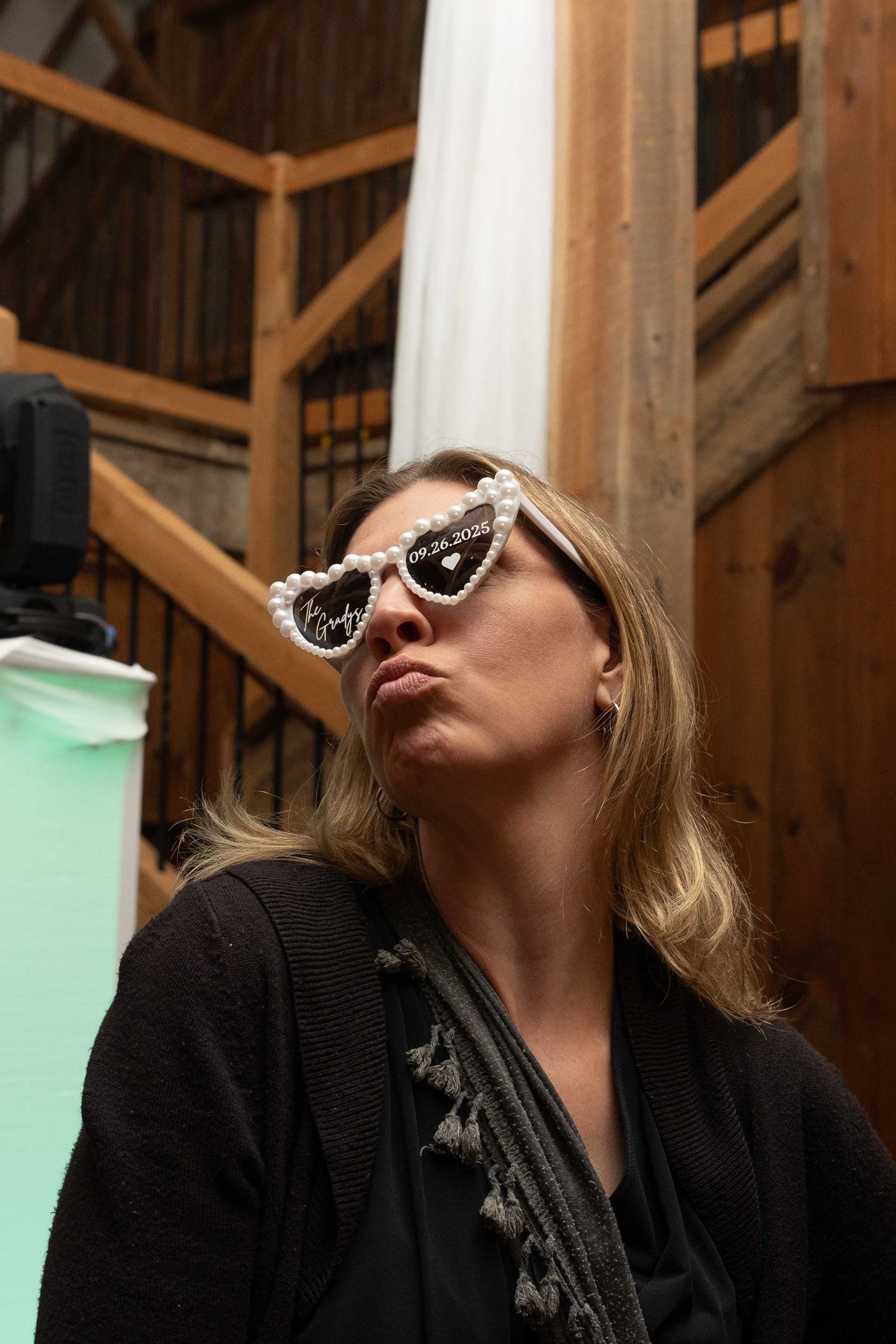 A series of four similar photos showing someone wearing sunglasses and a black outfit tilting their head back.
