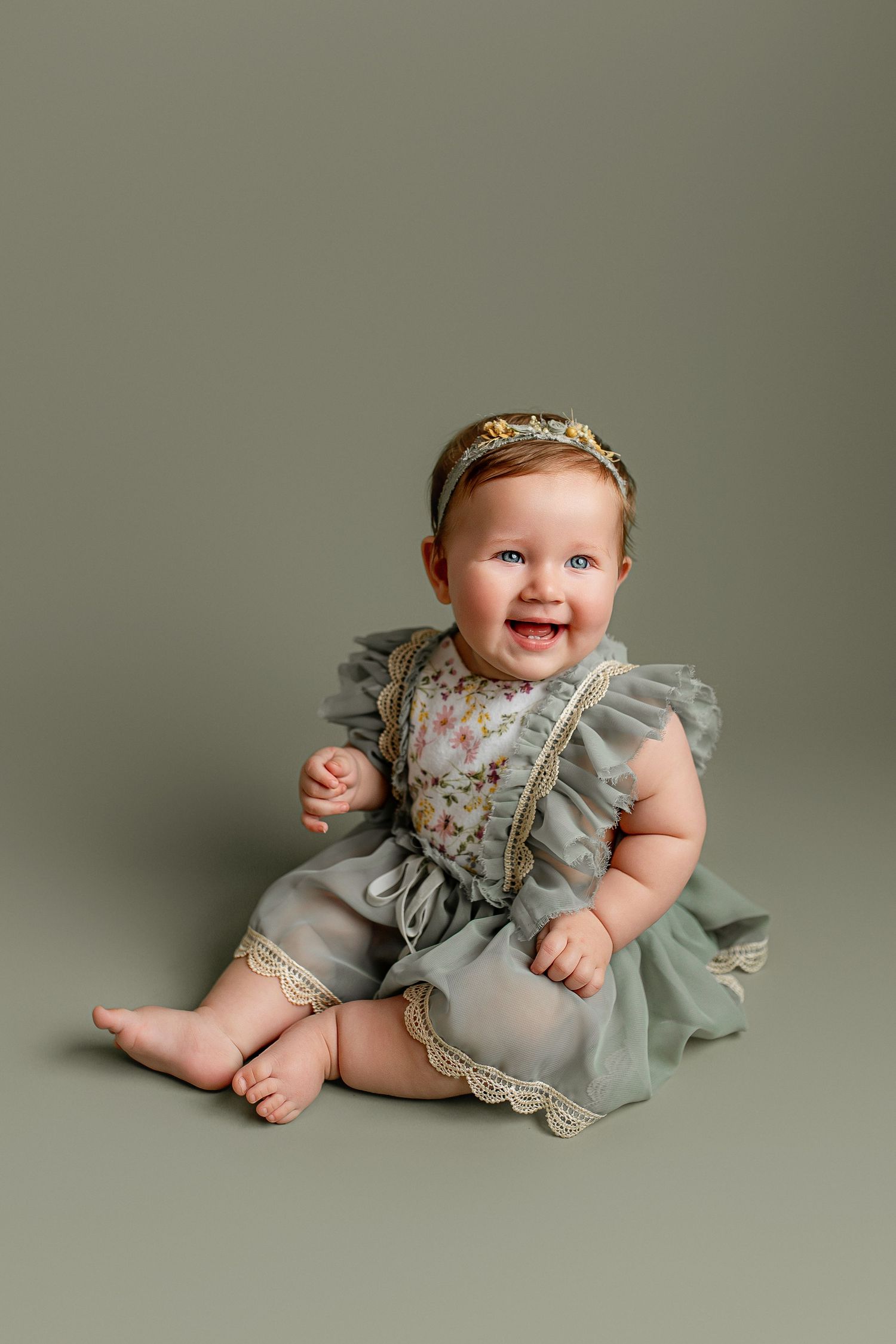 Baby sitter girl with green floral dress and headband at Flowertown Photography Studio in Summerville, SC