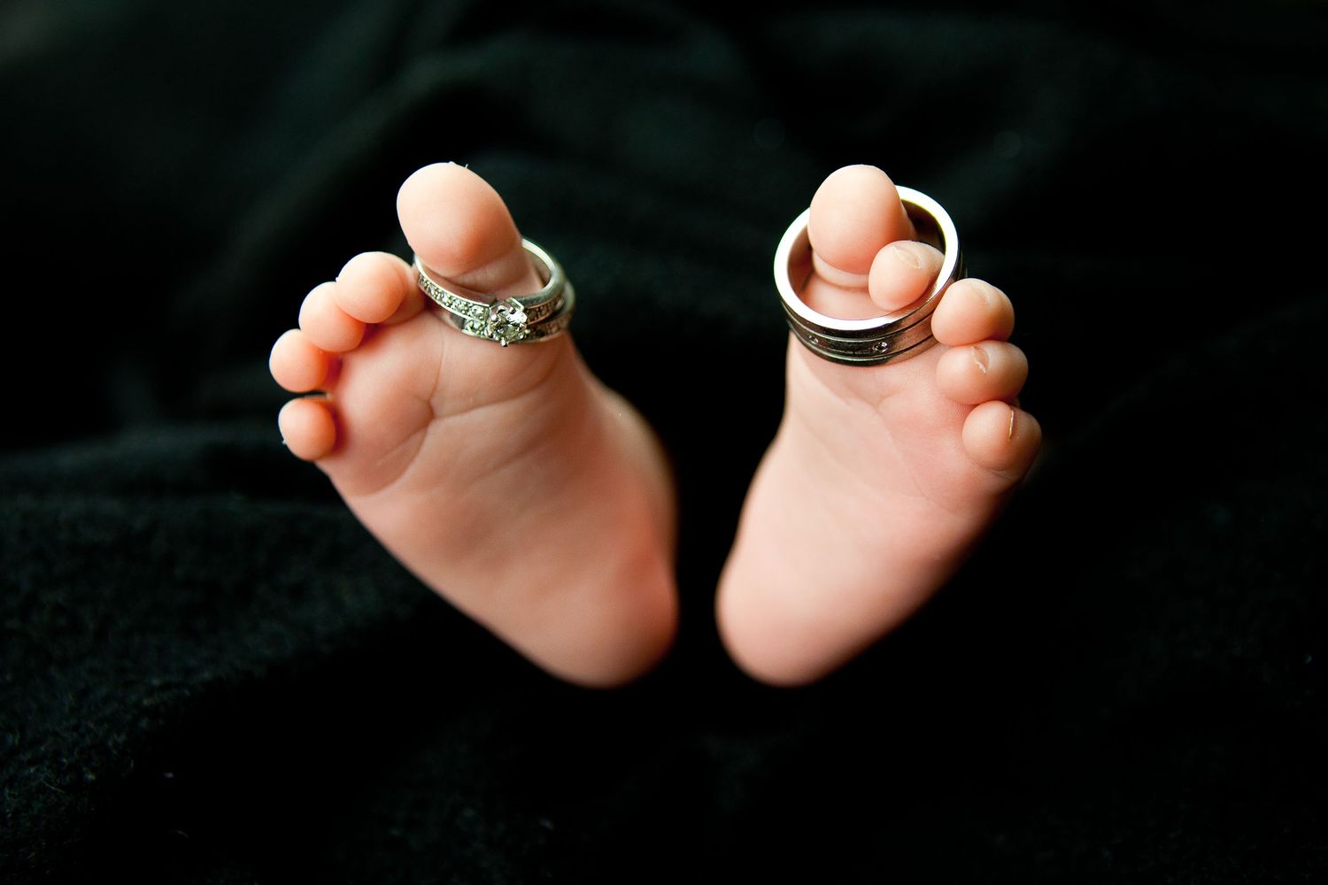 A series of close-up photos showing tiny baby feet with rings placed between the toes.