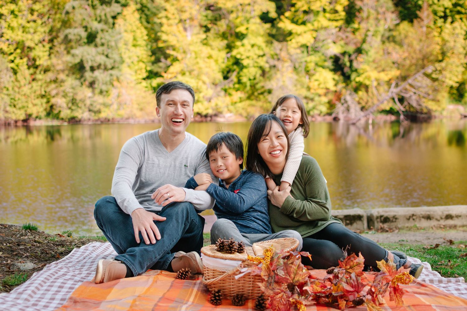 Joyful family photography session at a Seattle park with parents and children sitting together outdoors