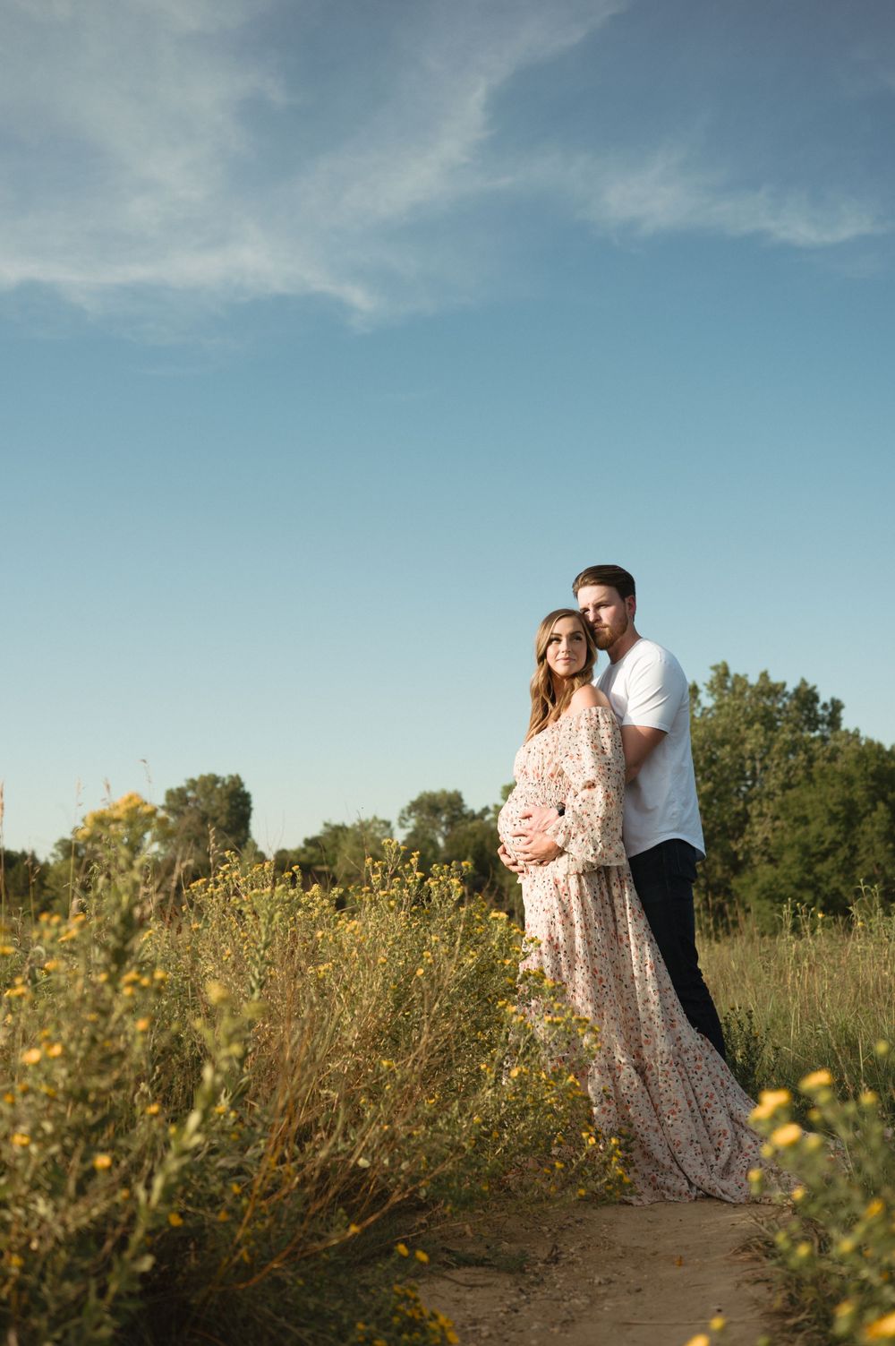 Intimate maternity portrait of an expectant mother in a field of green in Sioux Falls.