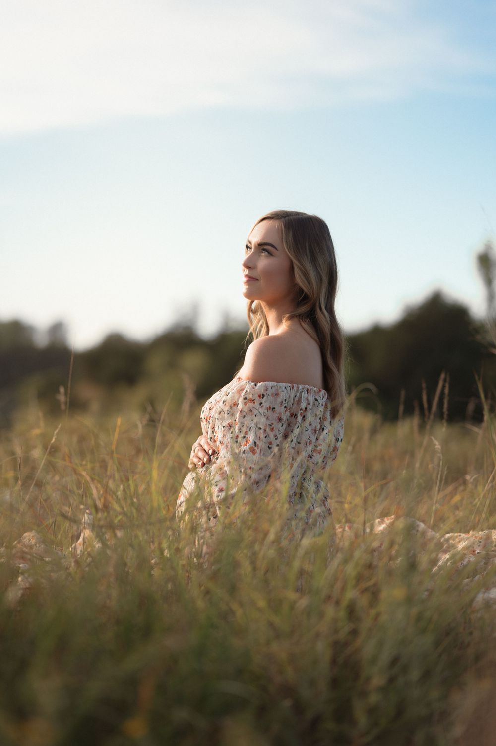 Intimate expectant mother in a whimsical flowy dress during an outdoor maternity session in Sioux Falls.