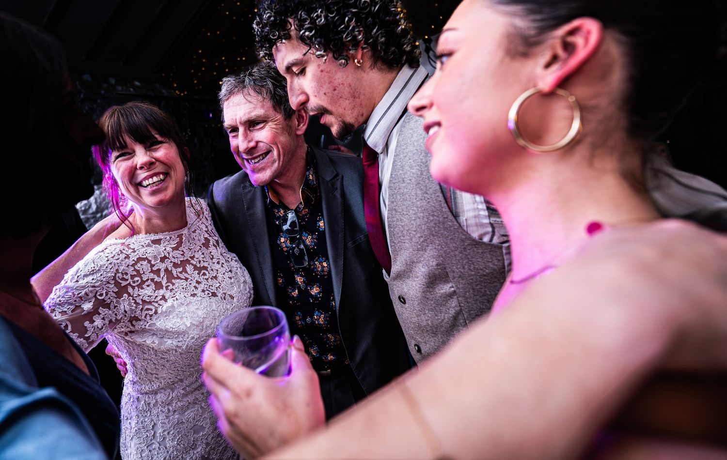 Group of adults laughing and socializing at a festive party event.