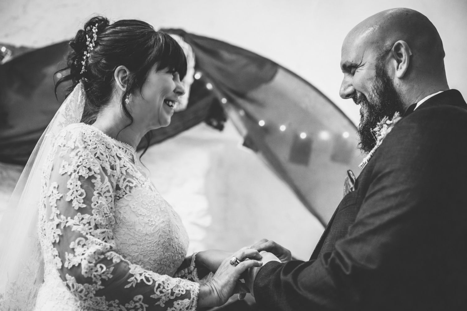 Bride and groom exchange rings during an emotional wedding ceremony.