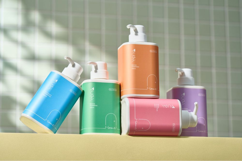 Colorful pump bottles in blue, green, orange, pink, and purple arranged on yellow surface.