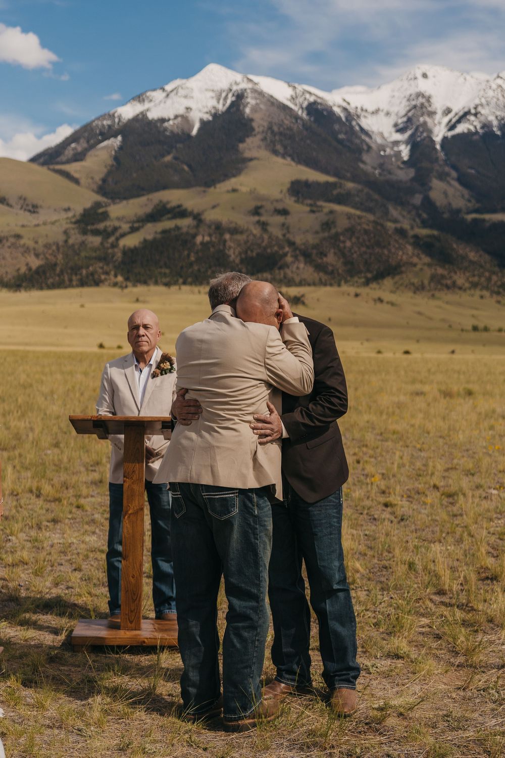 Groom hugging his father in Law during his intimate Wedding day under the Mountains near Chico Montana. Western Wedding Paradise Valley MT