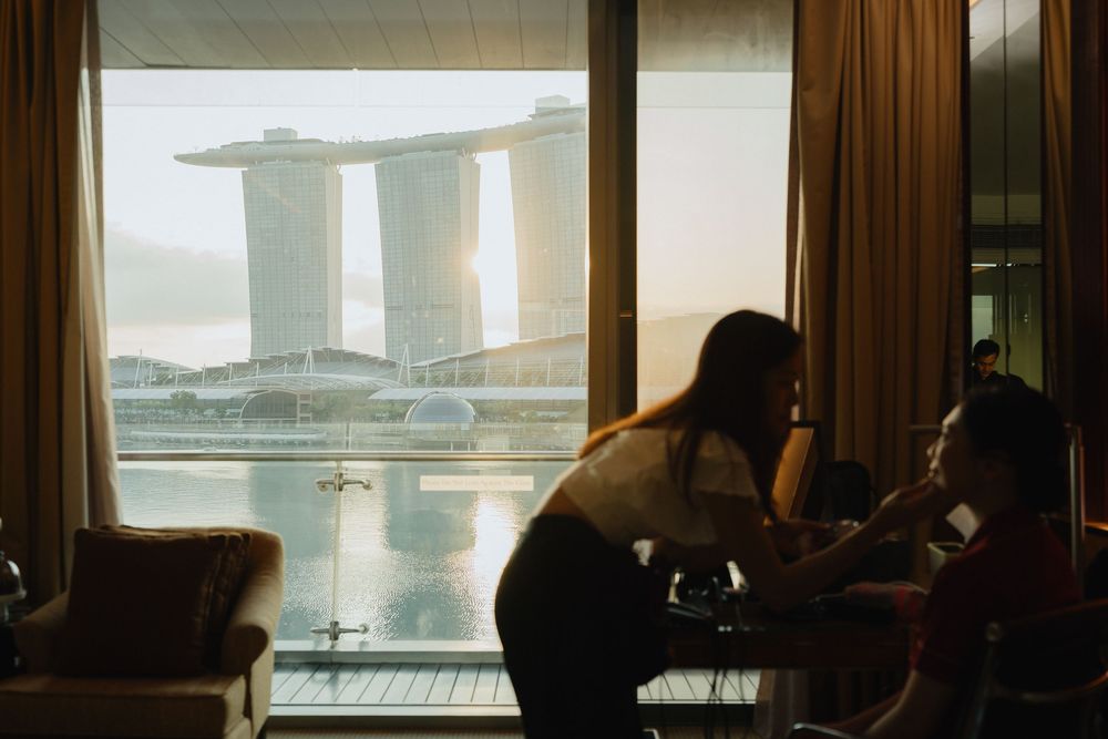 People relaxing in a luxury hotel room with a stunning view of Marina Bay Sands in Singapore.