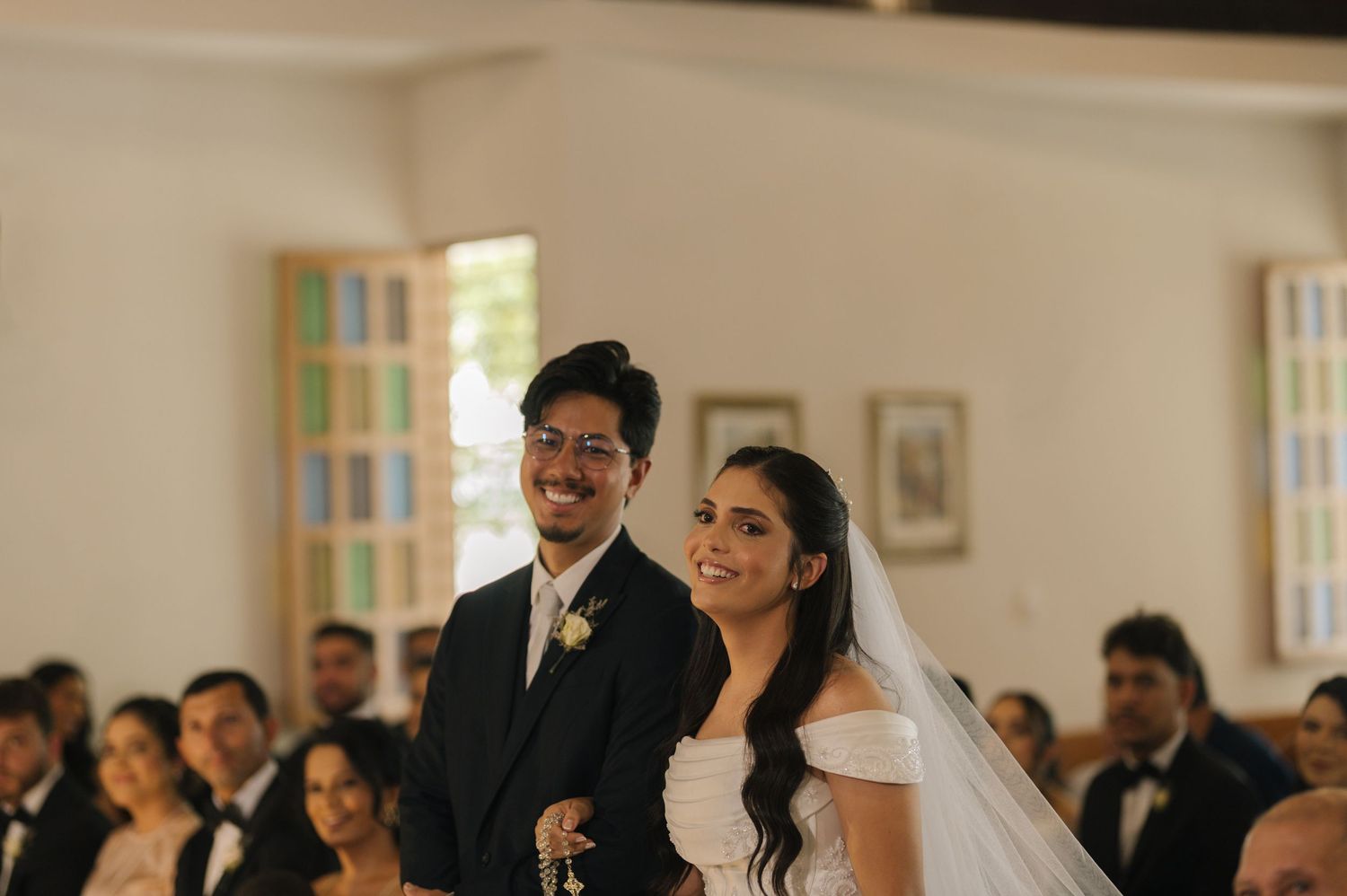 Smiling bride and groom stand at the altar during their church wedding ceremony.