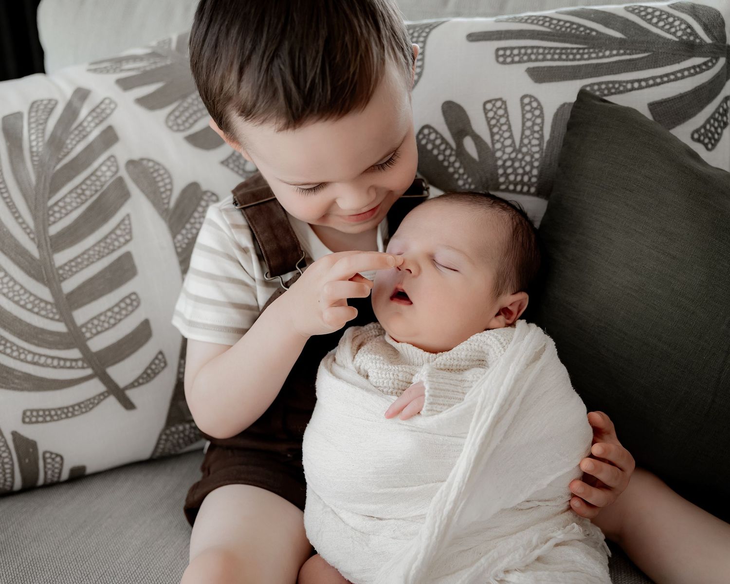 family cuddling newborn baby in Nelson photography studio