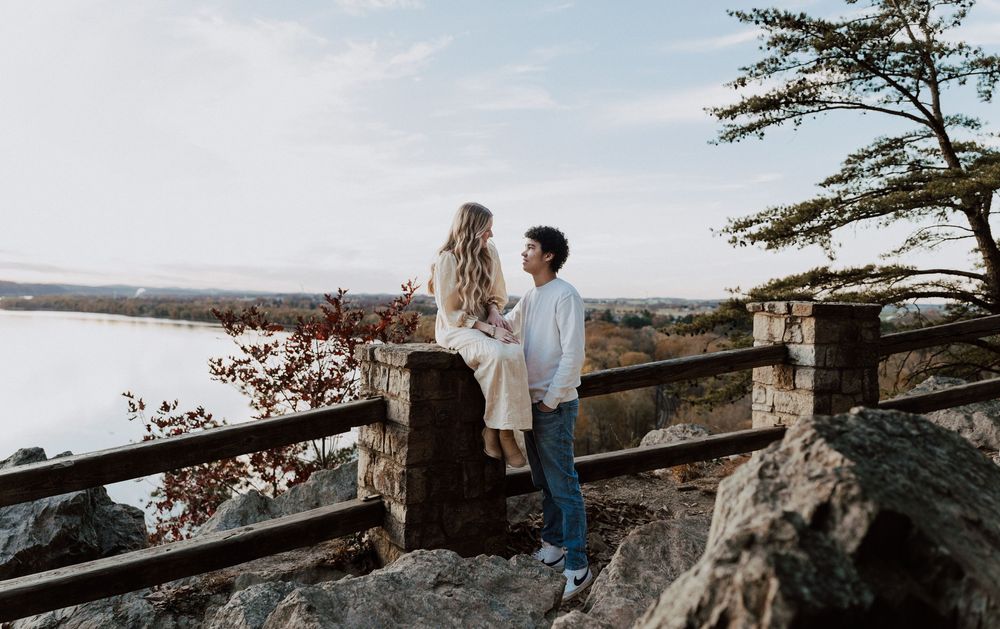 Couple taking engagement photos at Chickies Rock Overlook in Central PA, standing on a rocky overlook with scenic lake views,