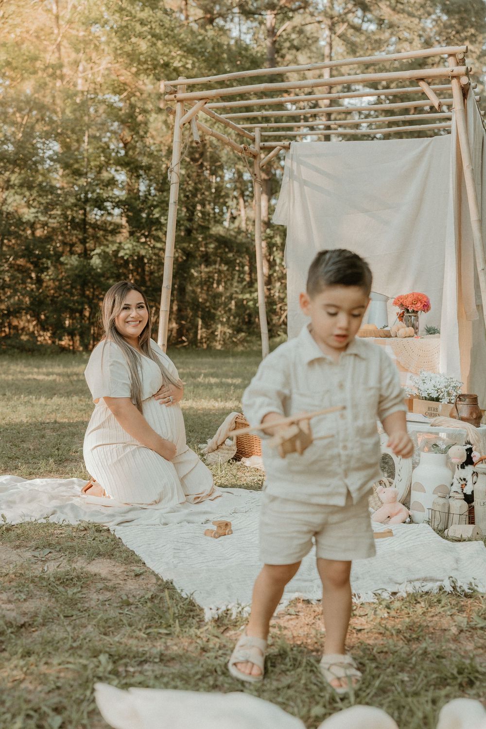 Natural outdoor setting with decorative white tent setup and vintage decor for a picnic gathering during golden hour.