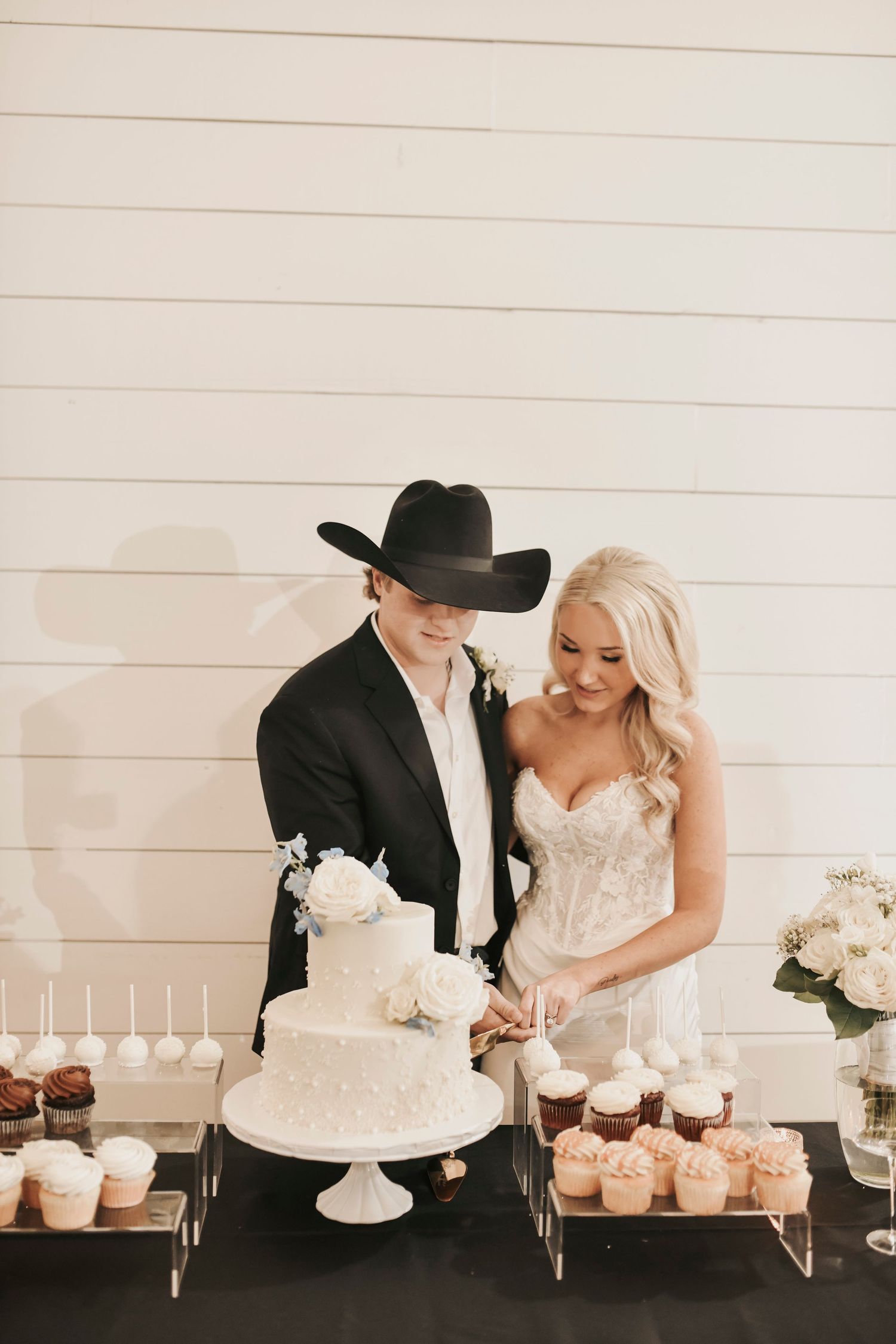 Bride and groom cutting elegant pearl wedding cake