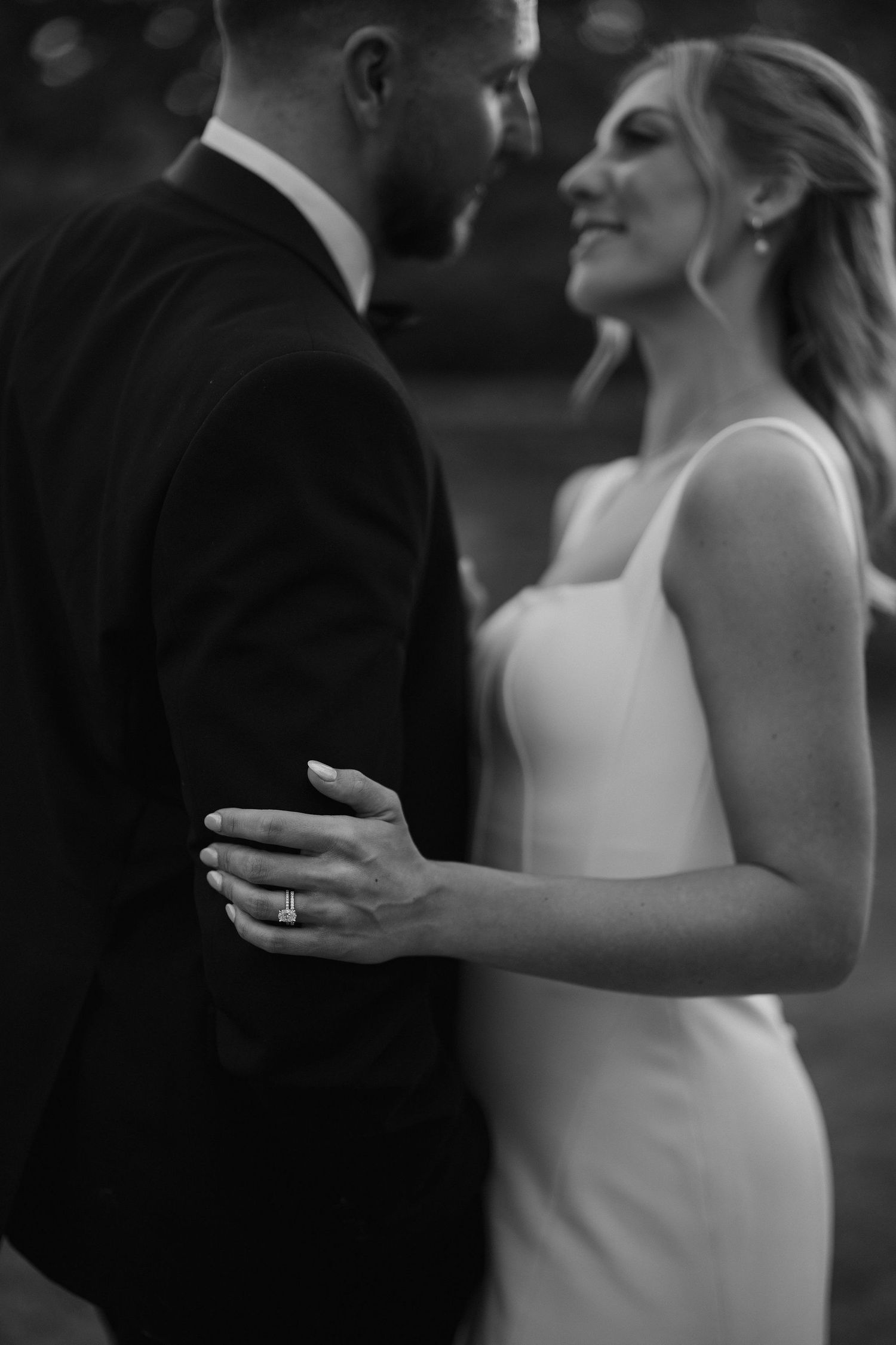 brides wedding rings as her hand holds onto the grooms arm at ivy lodge wedding in cirencester