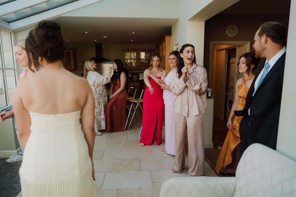 Wedding guests in colorful formal attire gather in a bright modern venue.