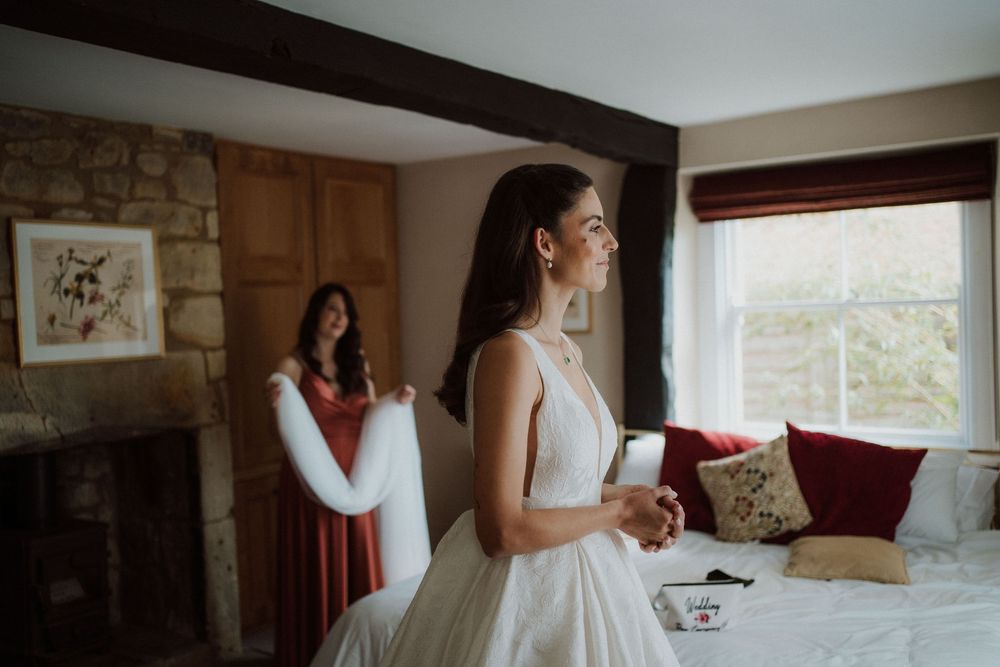 A quiet moment during wedding preparations in a rustic room with stone walls.