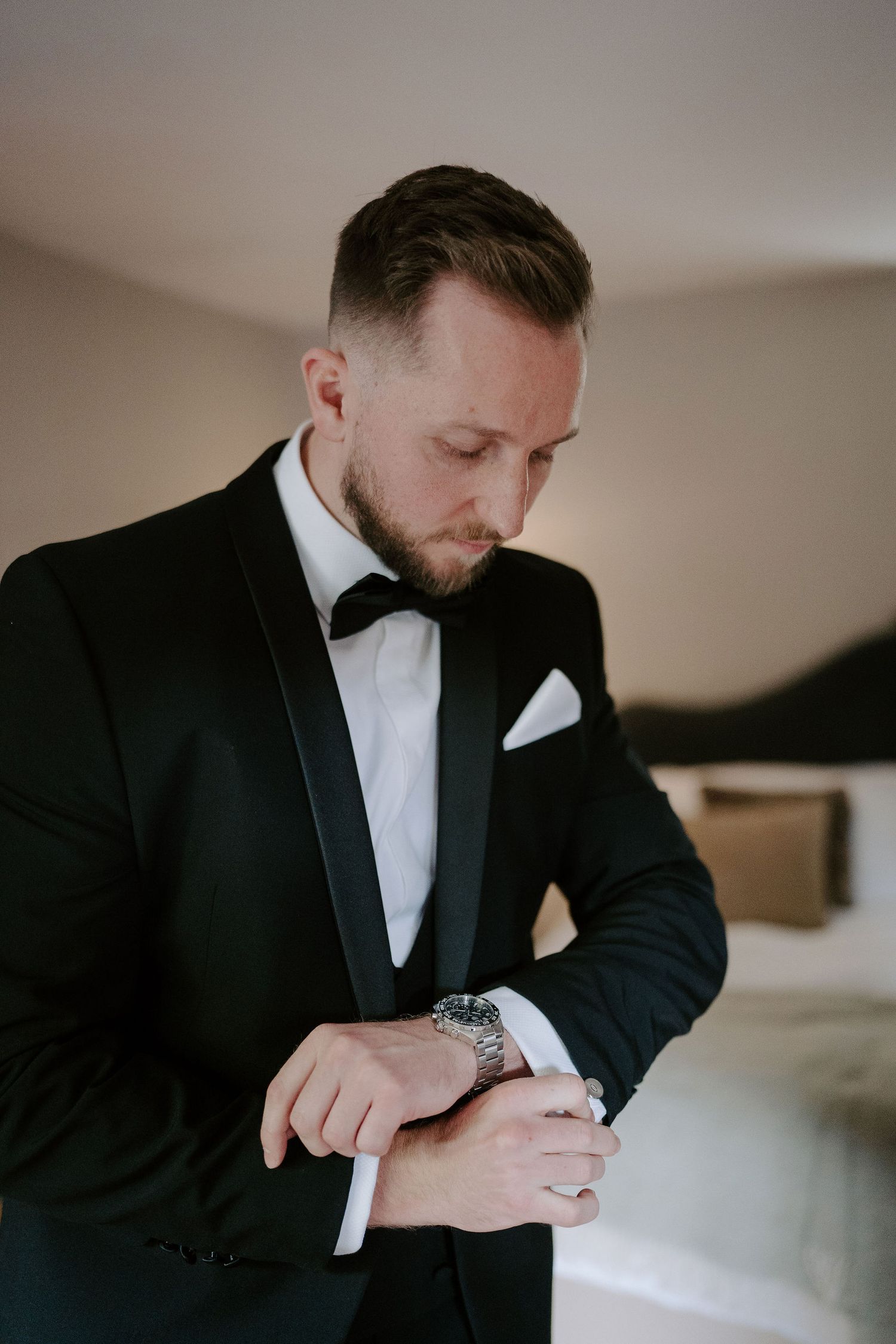 groom adjusting watch strap at ivy lodge in cirencester