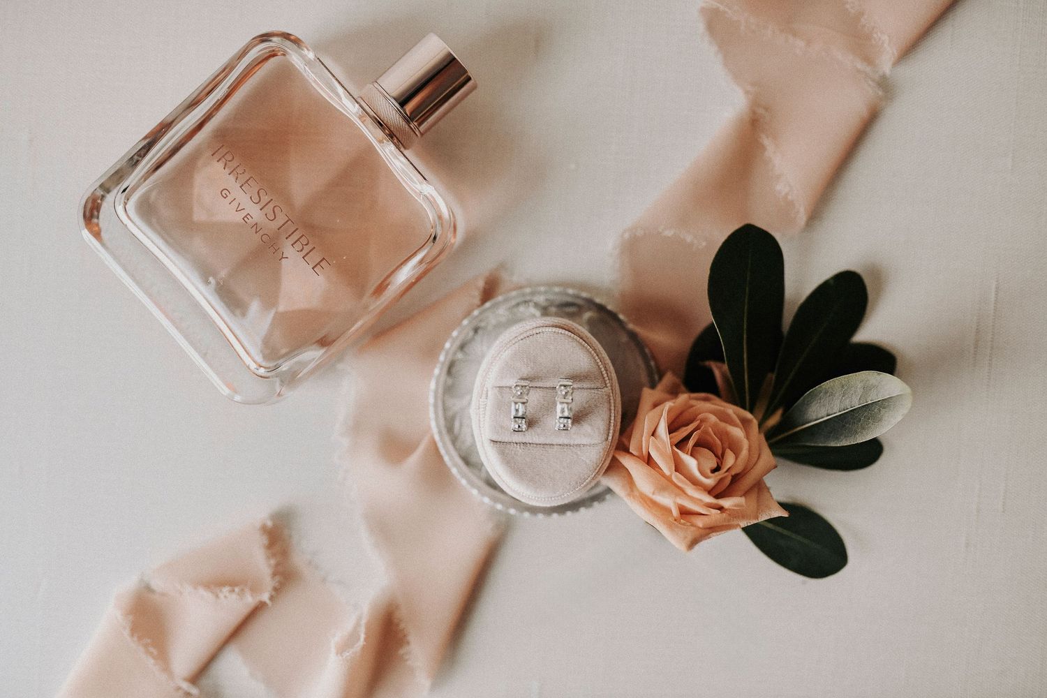Pink florals and loose greenery styled in a romantic spring wedding reception flat lay.