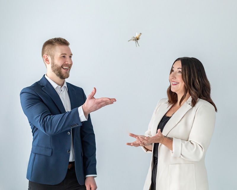 Real estate agents tossing house keys, symbolizing home purchase and closing