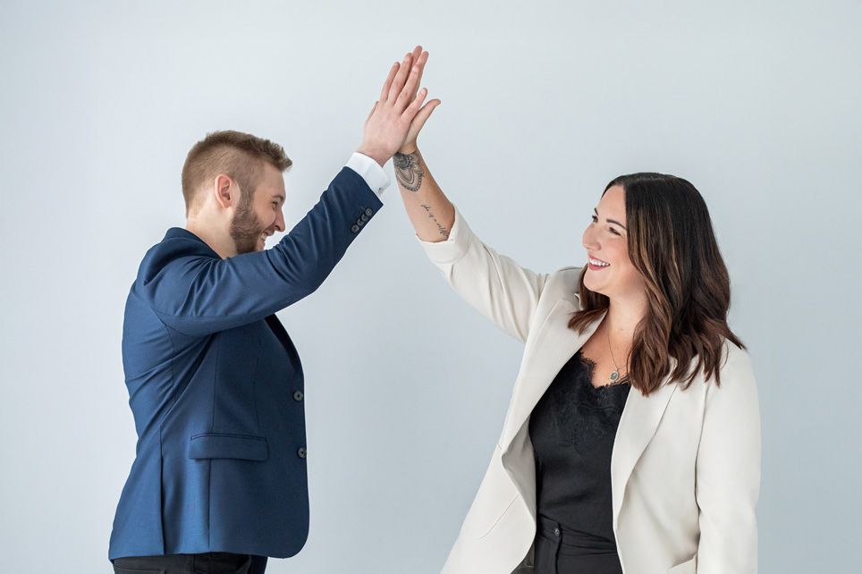 Real estate team celebrating success with high five, energetic branding photo