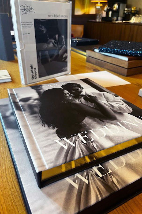 Multiple black and white photographic prints laid out on a wooden table surface in sequence.