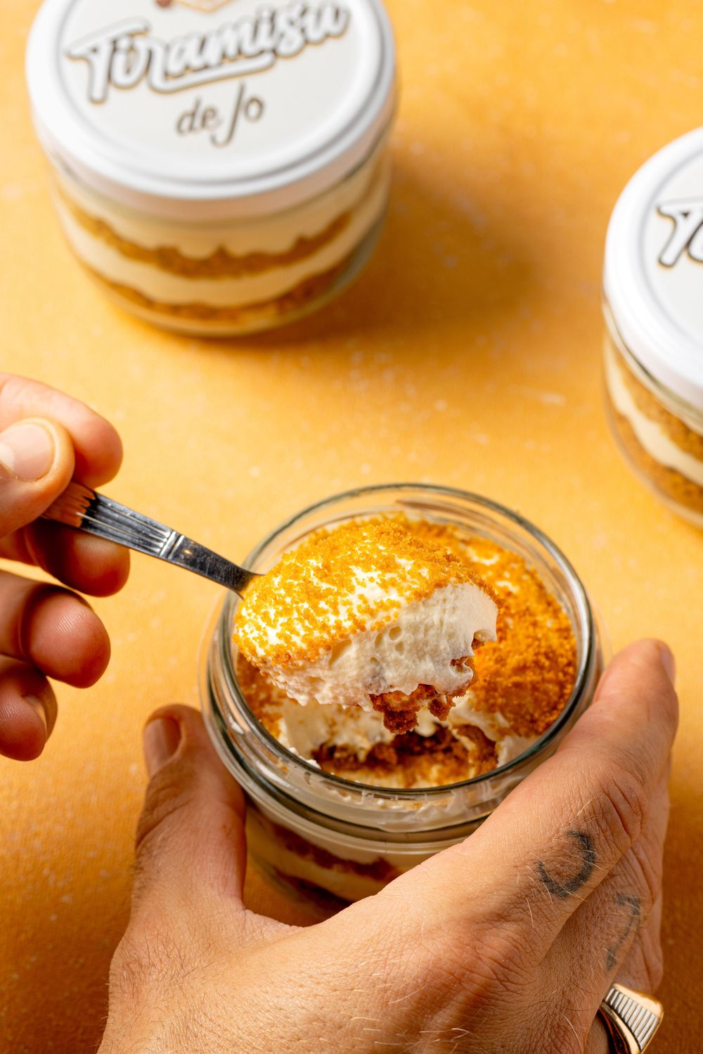 A sequence of images showing hands assembling individual chocolate trifle desserts in small glass jars.