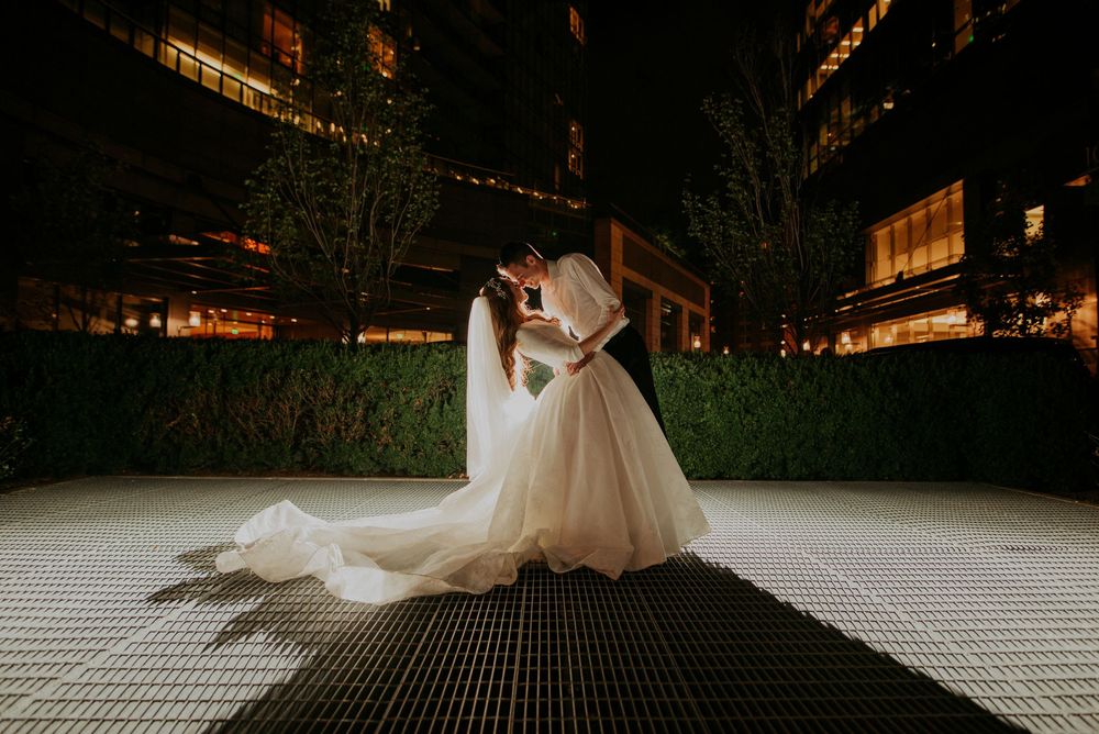Dramatic nighttime wedding portrait with creative lighting and shadows.