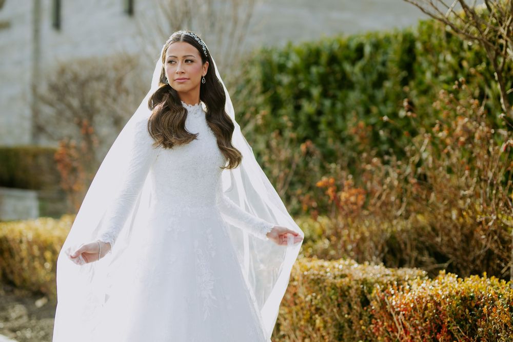 Ethereal winter bridal portraits with flowing white dress and cape.