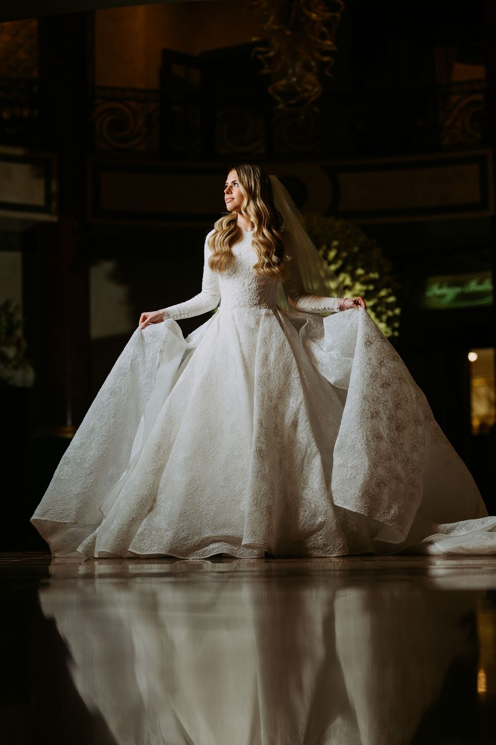 Artistic low-angle shot of wedding gowns creating reflections on polished floor.