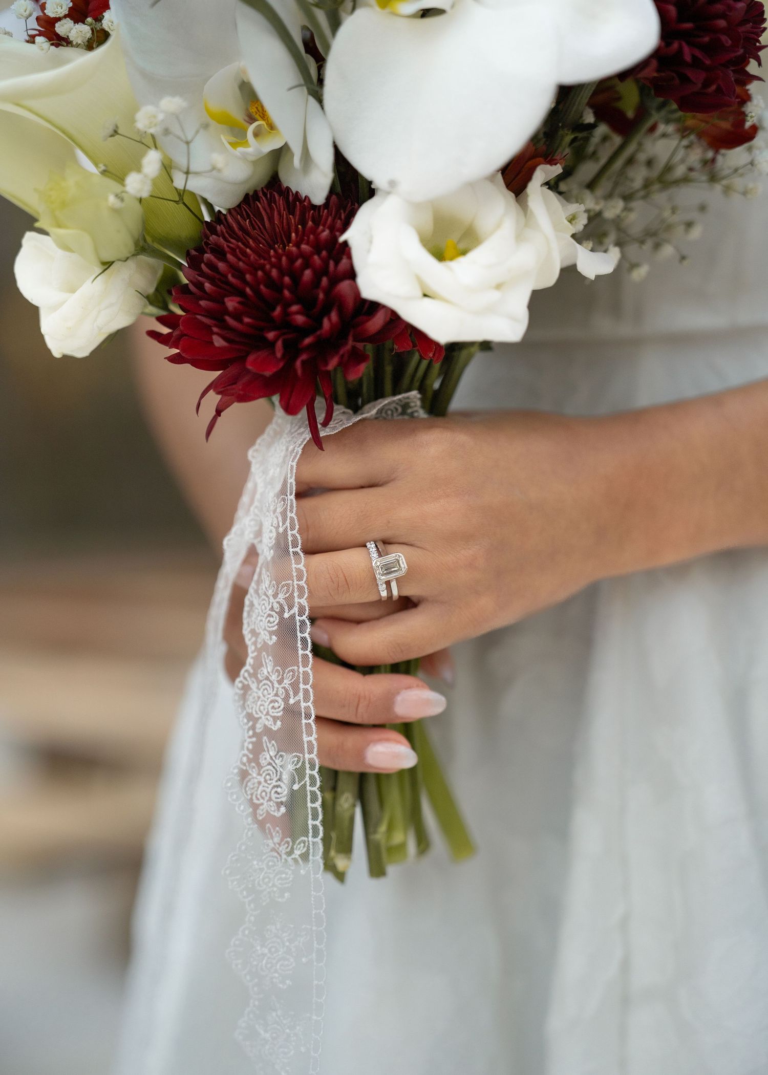 Close-up of couple’s hands and wedding rings among leaves during forest elopement in Texas woods