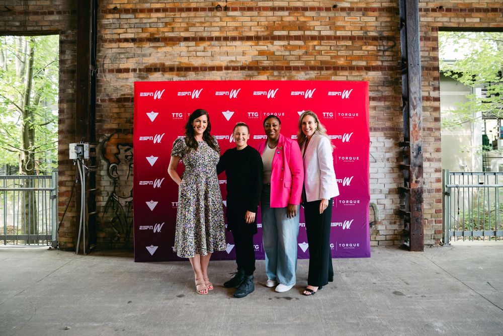 Group photo session against a brick wall backdrop with red banner display.