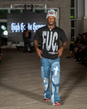 Streetwear look featuring distressed denim jeans and casual t-shirt on fashion runway.