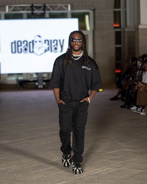 All-black casual streetwear ensemble presented during indoor fashion show.