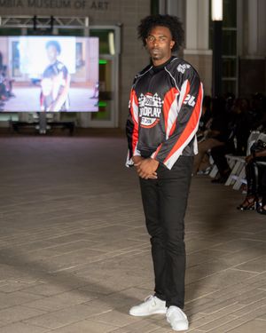 Fashion show featuring sporty black and red athleisure outfits on the runway.