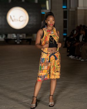 Colorful African print dress showcased on runway at Columbia Museum fashion event.