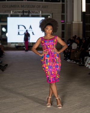 Vibrant pink and blue patterned dress showcased at Columbia Museum fashion event.