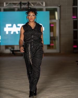 All-black streetwear ensemble with metallic accents presented during indoor fashion show.