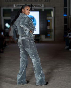 Silver velvet tracksuit shown from back view during fashion show at Columbia Museum of Art.