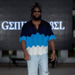 Fashion model presents blue and white patterned streetwear on concrete runway.