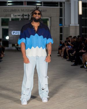 Gradient blue and white patterned top styled with distressed white jeans on museum runway.