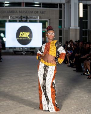 Models present bold animal print and geometric pattern designs during a fashion show.