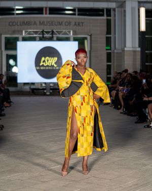 Model presents yellow matching set on runway at Columbia Museum fashion show.