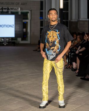 Yellow pants paired with graphic t-shirt displayed during fashion show.