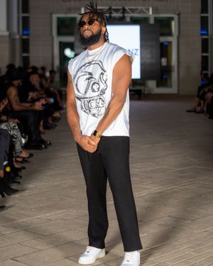 Casual white t-shirt and black pants combination presented at fashion show.