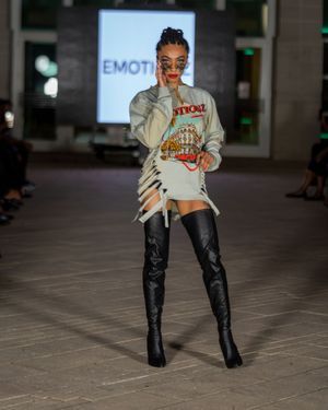 Model poses in grey sweatshirt and black leather boots during fashion show at Columbia Museum.