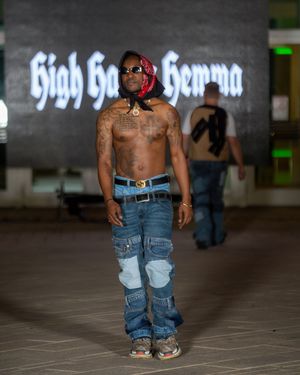 Models wearing distressed denim jeans walk the runway at a fashion show.